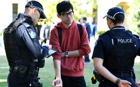 A man is questioned during a protest at Queensland University - Credit: Dave Hunt/REX