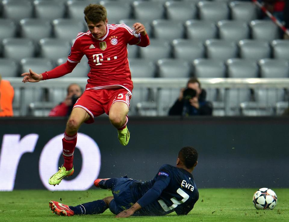 Bayern's Thomas Mueller, left, and Manchester United's Patrice Evra, right, challenge for the ball during the Champions League quarterfinal second leg soccer match between Bayern Munich and Manchester United in the Allianz Arena in Munich, Germany, Wednesday, April 9, 2014. (AP Photo/Kerstin Joensson)