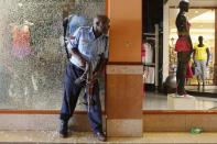 A police officer tries to secure an area inside the Westgate Shopping Centre where gunmen went on a shooting spree in Nairobi September 21, 2013. The gunmen stormed the shopping mall in Nairobi on Saturday killing at least 20 people in what Kenya's government said could be a terrorist attack, and sending scores fleeing into shops, a cinema and onto the streets in search of safety. Sporadic gun shots could be heard hours after the assault started as soldiers surrounded the mall and police and soldiers combed the building, hunting down the attackers shop by shop. Some local television stations reported hostages had been taken, but there was no official confirmation. (REUTERS/Siegfried Modola)