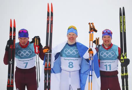 Cross-Country Skiing - Pyeongchang 2018 Winter Olympics - Men's 50km Mass Start Classic - Alpensia Cross-Country Skiing Centre - Pyeongchang, South Korea - February 24, 2018 - Winner Iivo Niskanen of Finland , flanked by Alexander Bolshunov, Olympic athlete from Russia, and Andrey Larkov, Olympic athlete from Russia, pose after finishing the race. REUTERS/Carlos Barria