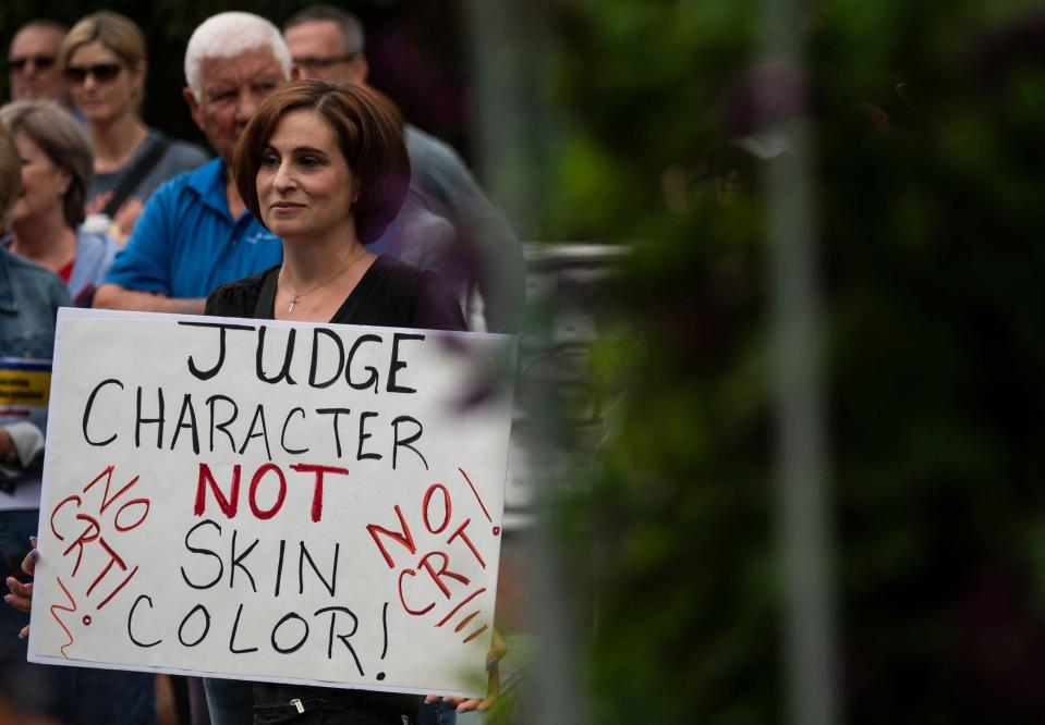 A woman holds up a sign during a rally against "critical race theory" (CRT) being taught in schools at the Loudoun County Government center in Leesburg, Virginia on June 12, 2021.