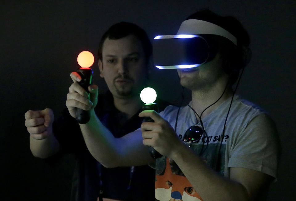 Marcus Ingvarsson, right, tests out the PlayStation 4 virtual reality headset Project Morpheus in a demo area at the Game Developers Conference 2014 in San Francisco, Wednesday, March 19, 2014. (AP Photo/Jeff Chiu)