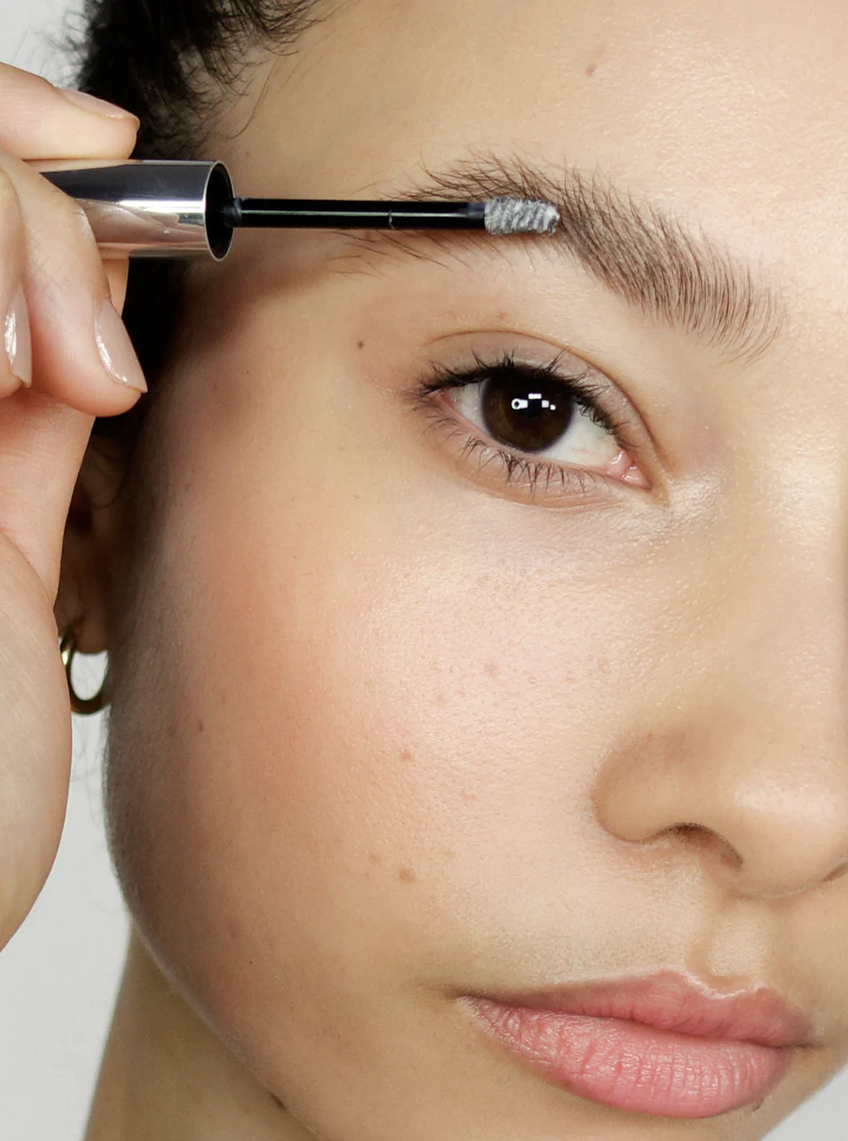 woman applying Glossier Boy Brow to eyebrow (Photo via Glossier)