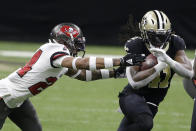 New Orleans Saints running back Alvin Kamara, right, runs against Tampa Bay Buccaneers cornerback Carlton Davis during the first half of an NFL divisional round playoff football game, Sunday, Jan. 17, 2021, in New Orleans. (AP Photo/Butch Dill)