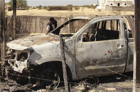 A man inspects the wreckage of a burnt car after assaults on militants by the Egyptian Army, in a village on the outskirts of Sheikh Zuweid, near the city of El-Arish in Egypt's Sinai peninsula in this September 10, 2013 file photo. REUTERS/Stringer/Files