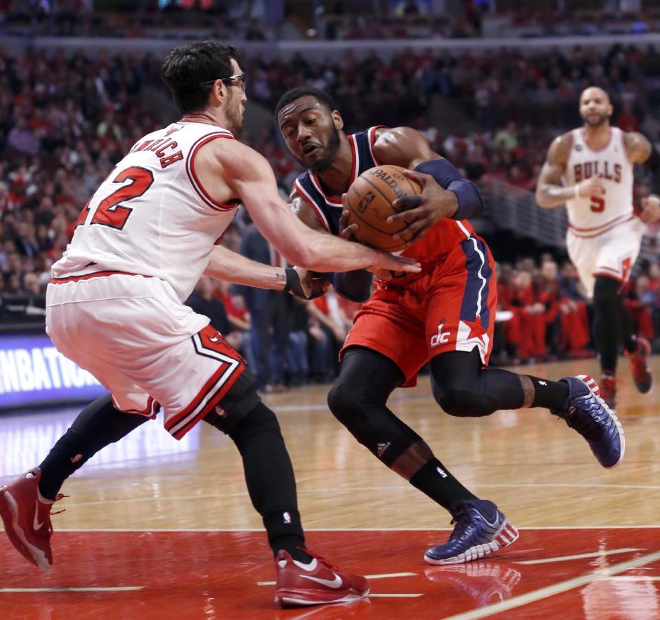 Washington Wizards guard John Wall, right, drives on Chicago Bulls guard Kirk Hinrich (12) during the first half of Game 2 in an opening-round NBA basketball playoff series Tuesday, April 22, 2014, in Chicago. (AP Photo/Charles Rex Arbogast)