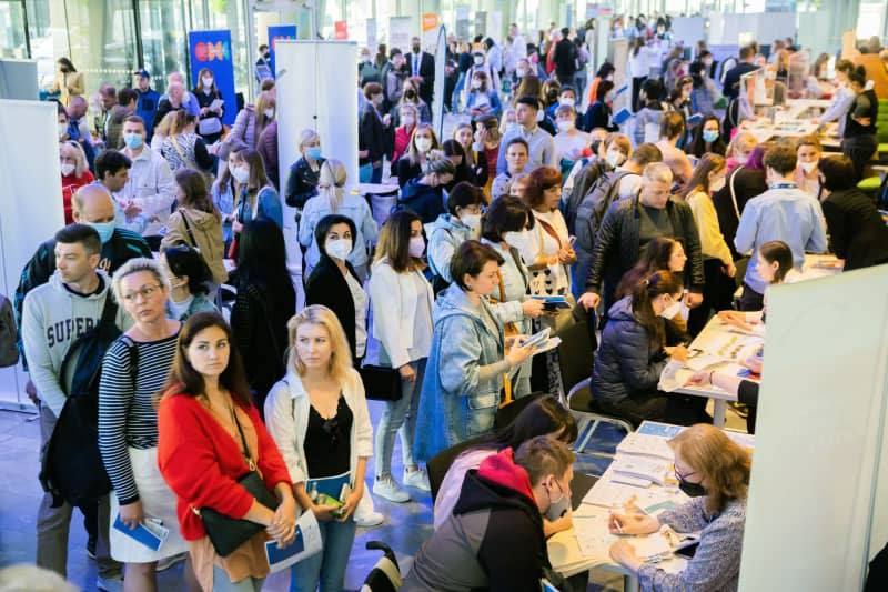 Ukrainian refugees stand in front of information booths during a job fair organized by the Berlin Chamber of Industry and Commerce and the Employment Agency. Immigrants have helped keep the German economy humming and the country's labour market from collapsing, the leader of Germany's Federal Employment Agency said on Wednesday. Christoph Soeder/dpa