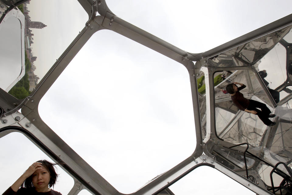 Visitors look at a structure by Tomas Saraceno called "Cloud City" during a media preview on the rooftop of the Metropolitan Museum of Art in New York, Monday, May 14, 2012. The maker of Cloud City, Argentine artist Tomas Saraceno, wants to provoke the feeling of being in a cloud floating in the middle of several realities. (AP Photo/Seth Wenig)