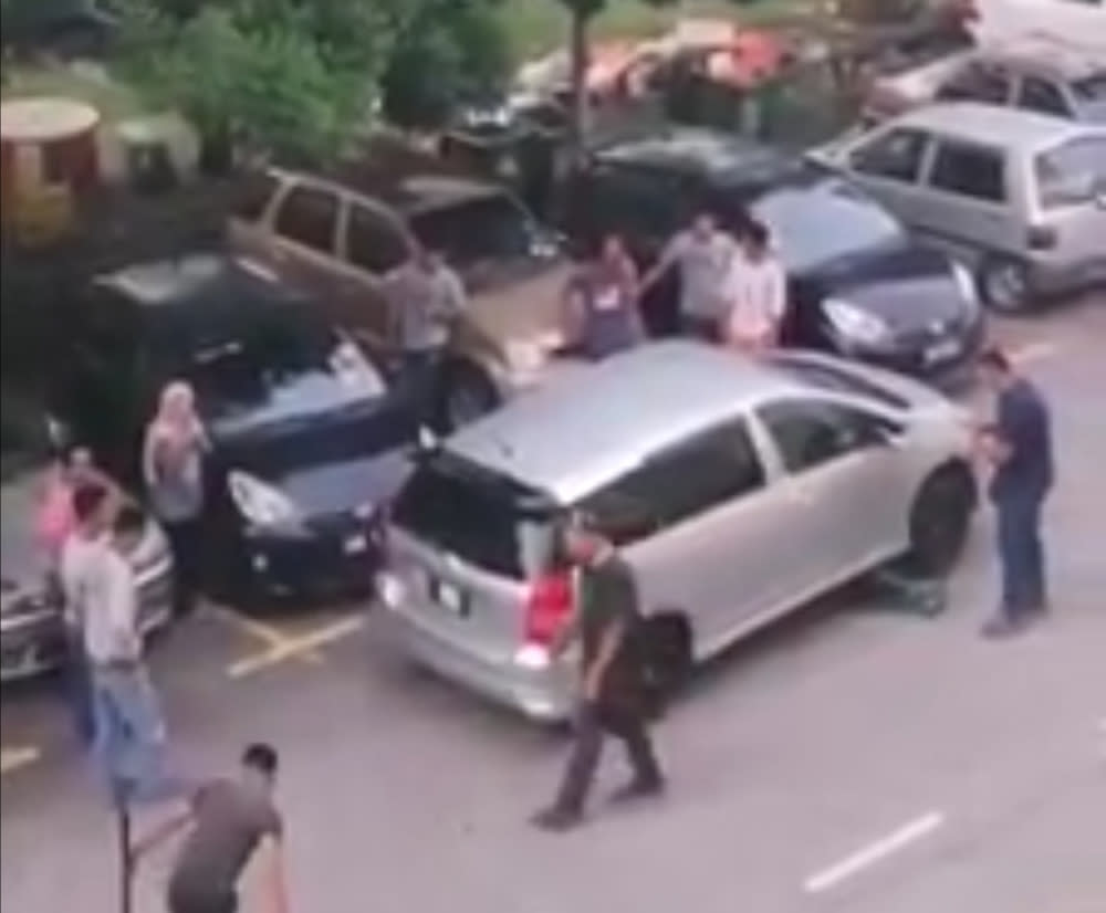 Teamwork is everything for this group of men helping move the inconsiderately double parked car. — Facebook/ We are Malaysians