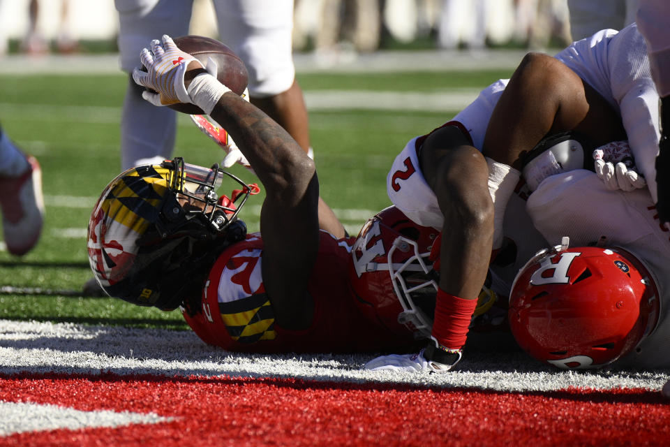 Maryland running back Roman Hemby (24) raises the football after he scored a touchdown during the first half of an NCAA college football game next to Rutgers defensive back Avery Young (2), Saturday, Nov. 26, 2022, in College Park, Md. (AP Photo/Nick Wass)