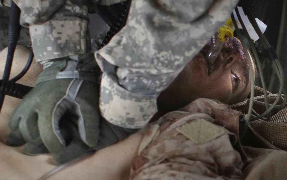 <p>A U.S. Army medevac crew member attempts to revive a Marine mortally wounded in an IED (improvised explosion device) blast near the town of Marjah in Helmand province, Aug. 22, 2010. (Photo: Bob Strong/Reuters) </p>