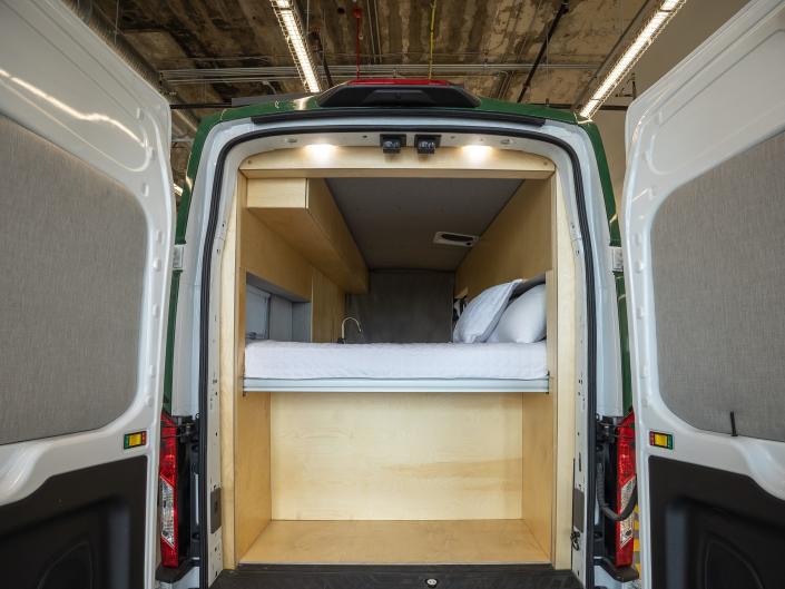 Inside Grounded&#39;s camper van with a bed