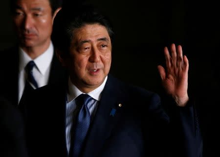 Japan's Prime Minister Shinzo Abe raises his hand as he walks at his official residence in Tokyo, Japan March 16, 2017. REUTERS/Toru Hanai