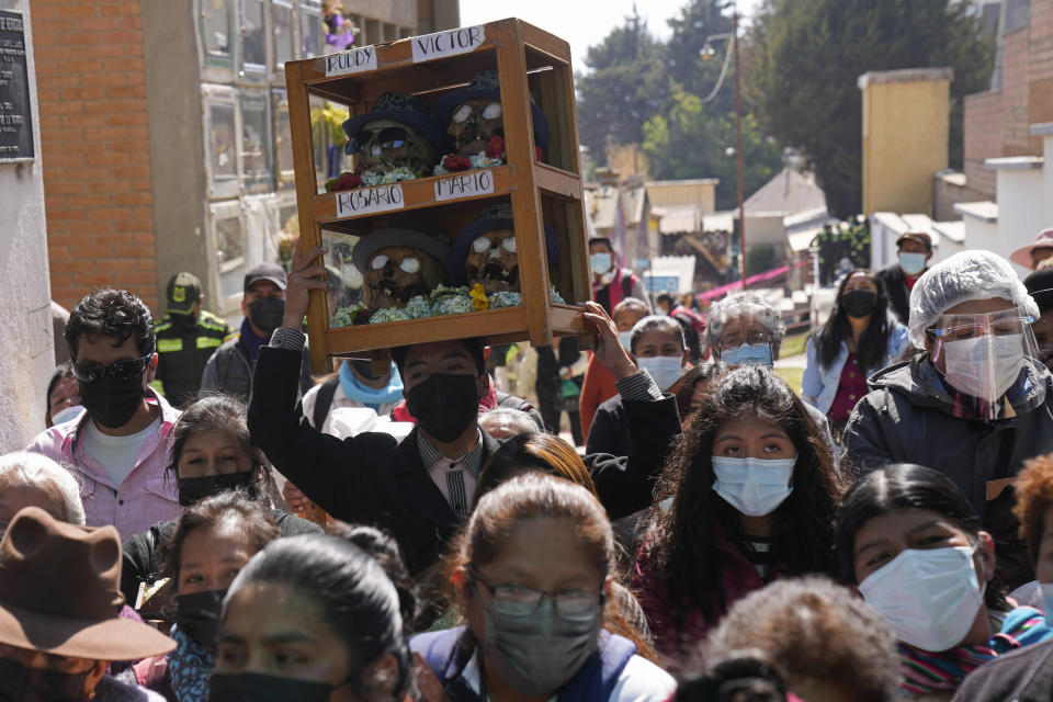 Una persona lleva una caja de calaveras humanas decoradas en el Cementerio General para ser bendecidas por un sacerdote en la fiesta anual de las ñatitas, una tradición que marca el final de la festividad católica de Todos los Santos en La Paz, Bolivia, el martes 8 de noviembre de 2019. (AP Foto/Juan Karita)