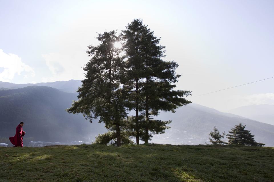 A novice monks walks along a hilltop at the Dechen Phrodrang Buddhist monastery in Bhutan's capital Thimphu