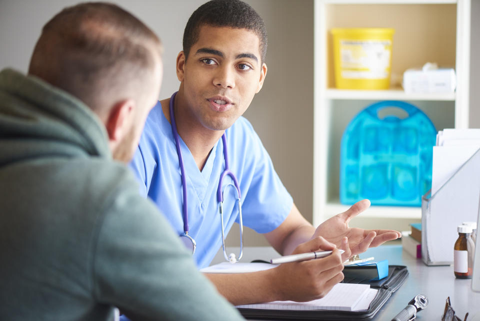 male gp sits with his male patient andchats to him  . He has listened to all his symptoms and has come up with an assessment and area he needs to look at.