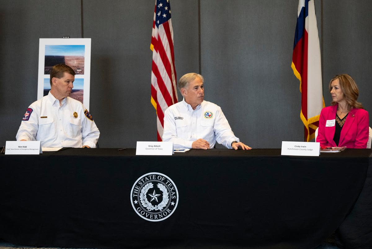 Texas Governor Greg Abbott, center, speaks at a press conference with Nim Kidd chief of the Texas Division of Emergency Management, left, and Hutchinson County Judge Cindy Irwin, right, Friday, March. 1, 2024, in Borger, Texas.
