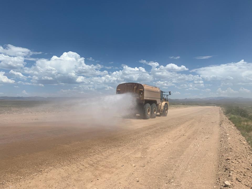 A tanker sprays water on Geronimo Trail Road east of Douglas on Aug. 13, 2020. The dirt road goes through a known human smuggling corridor and has been widened and flattened to access border wall construction sites, but smugglers use the road as well.