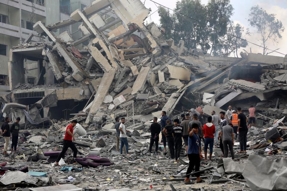 Palestinians inspect the damage of a destroyed building following Israeli airstrikes on Gaza City, Thursday, Oct. 19, 2023.