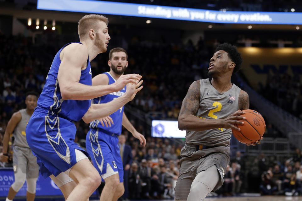 Marquette's Sacar Anim drives to the basket against multiple Creighton defenders during the first half of an NCAA college basketball game Tuesday, Feb. 18, 2020, in Milwaukee. (AP Photo/Aaron Gash)