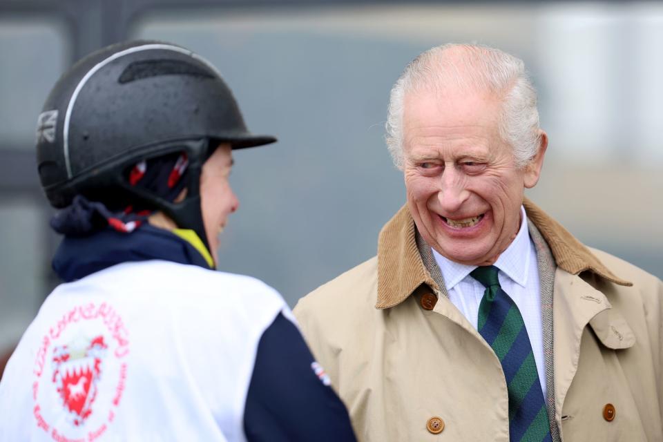 King Charles is all smiles as he chats with a jockey