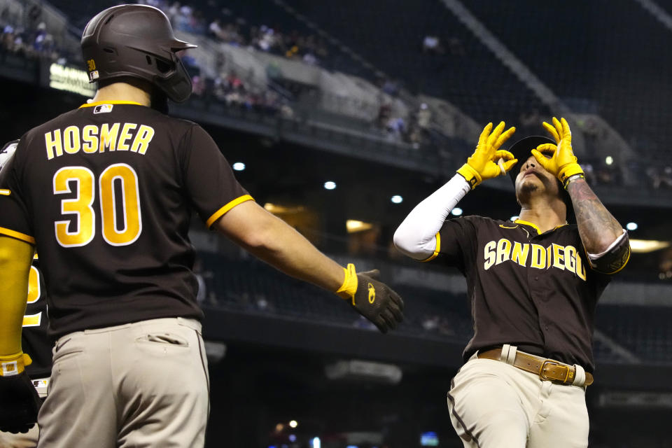 San Diego Padres' Manny Machado celebrates with Eric Hosmer (30) after hitting a two run home run against the Arizona Diamondbacks in the fifth inning during a baseball game, Tuesday, Aug. 31, 2021, in Phoenix. (AP Photo/Rick Scuteri)