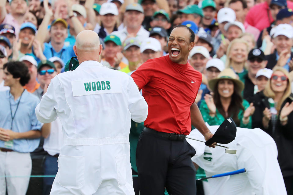 Tiger Woods (R) of the United States celebrates with caddie Joe LaCava (L) on the 18th green after winning during the final round of the Masters at Augusta National Golf Club on April 14, 2019 in Augusta, Georgia. (Photo by David Cannon/Getty Images)