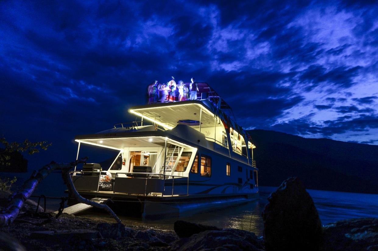 Dancing and partying while enjoying the beautiful twilight sunset sky aboard a houseboat on Shuswap Lake in British Columbia