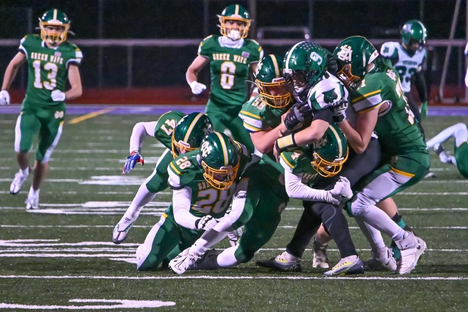 Newark Catholic juniors Connor McKenna (34) and Nate Willis (58) and senior Bradyn Ehret (71) wrap up Waterford senior quarterback Jacob Pantelidis during a Division VII, Region 27 semifinal at Logan on Saturday, Nov. 12, 2022. The Green Wave beat the Wildcats 35-7.