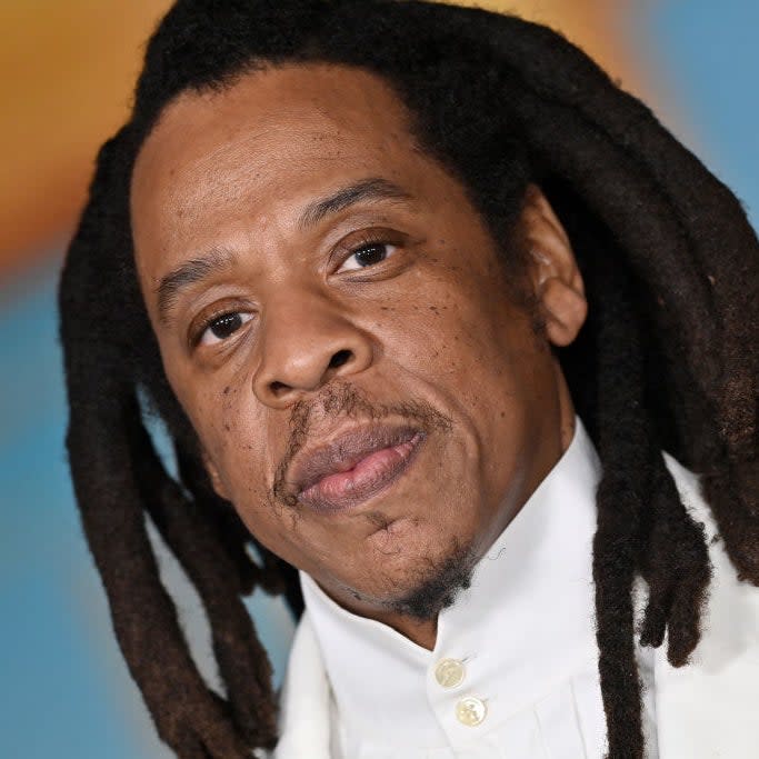 Close-up of a person with braided hair wearing a white buttoned shirt