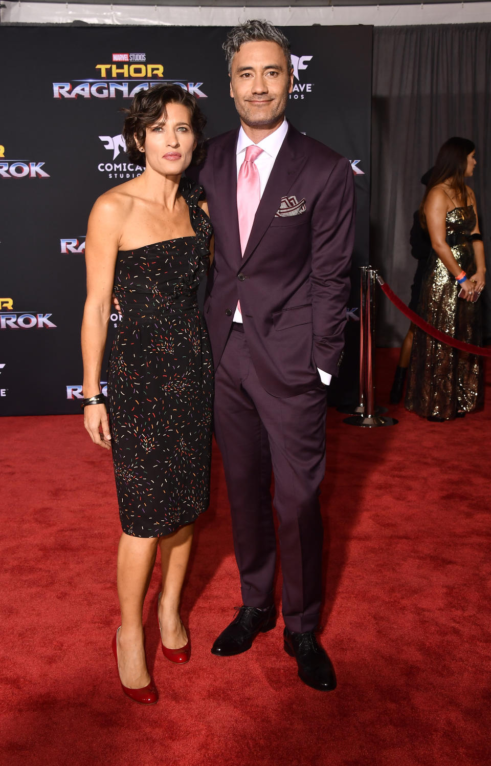 The former couple on the red carpet, she in a strapless knee-length dress and he in a suit and tie