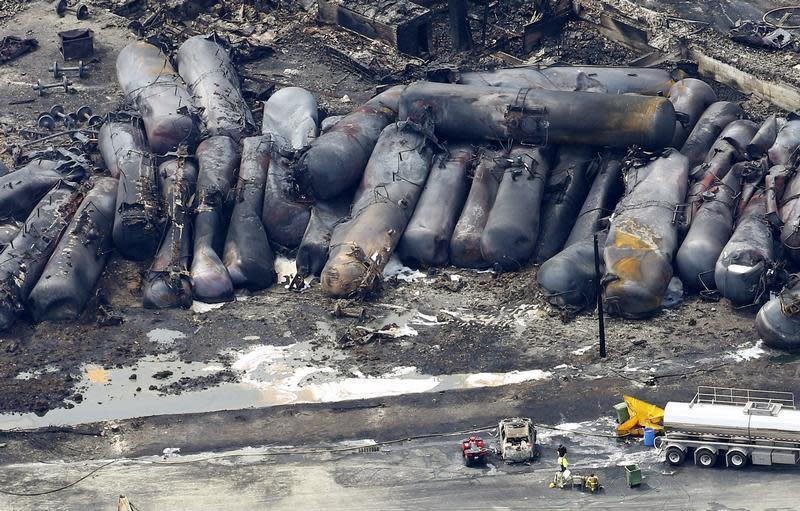 A firefighter stands close to the remains of a train wreckage in Lac Megantic