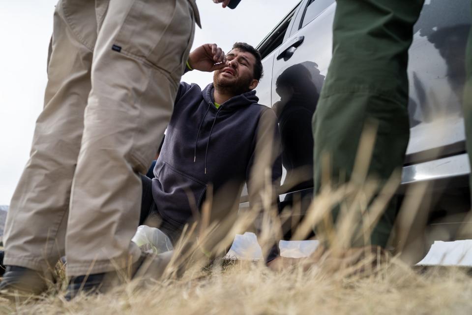 A man, stopped on suspicion of human trafficking of three migrants, speaks to a pair of U.S. Border Patrol agents on Feb. 17, 2023, in Hereford. The man, along with an accomplice, drove his mother's car from California and stopped to pick up the migrants on the side of the highway in front of a Border Patrol agent, authorities said.