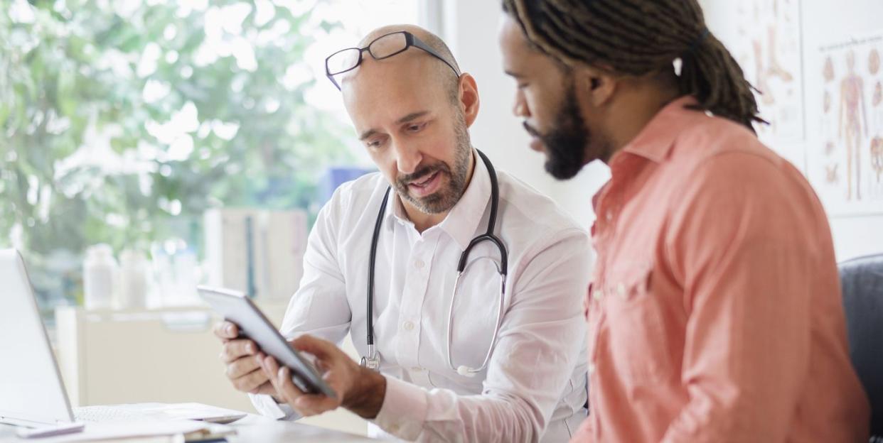 doctor giving consultation to patient using digital tablet