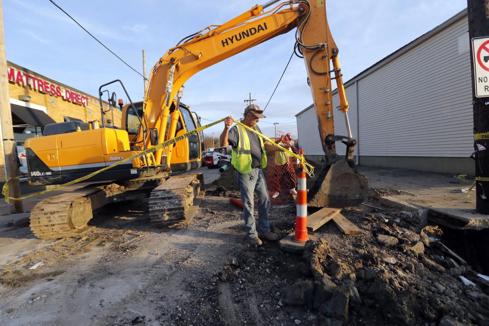 FILE - In this Jan. 31, 2018, file photo, workers fix a sewer main below the sidewalk in Mid City New Orleans. New Orleans' mayor says the city deserves to get a bigger percentage of the $166 million collected each year from a 15 percent surcharge on hotel rooms. The Southern tourist destination is grappling with longstanding infrastructure challenges, including potholes, drainage problems and sporadic drinking water issues. (AP Photo/Gerald Herbert, File)