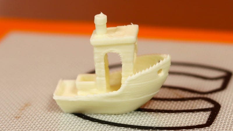 A small 3D-printed model of a boat made out of white chocolate.