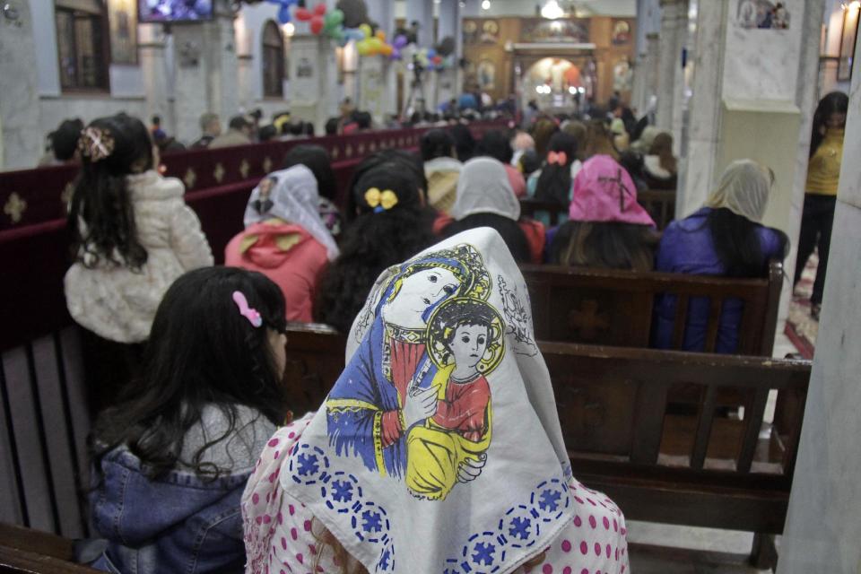 Worshippers attend Orthodox Christmas Eve Mass, where an Oct. 2013 deadly drive-by-shooting killed several at a wedding party, in the Warraq neighborhood of Cairo, Egypt late Monday, Jan. 6, 2014. Millions of Egyptian Christians on Monday thronged churches across the mainly Muslim nation for Christmas Mass, held amid unusually tight security but with congregations filled with hope ahead of a key vote this month on constitutional amendments that enshrine equality and criminalize all types of discrimination. (AP Photo/Aly Hazzaa, El Shorouk Newspaper) EGYPT OUT