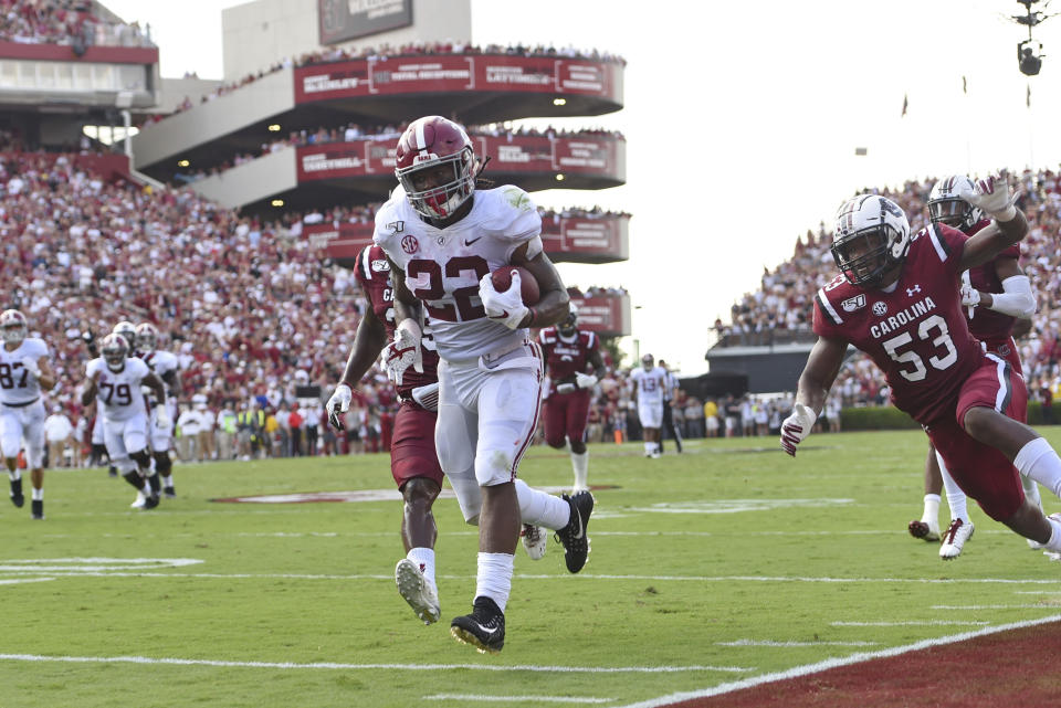Alabama's Najee Harris, center, rushes past South Carolina's J.T. Ibe, left, and Ernest Jones for a touchdown during the first half of an NCAA college football game Saturday, Sept. 14, 2019, in Columbia, S.C. (AP Photo/Richard Shiro)