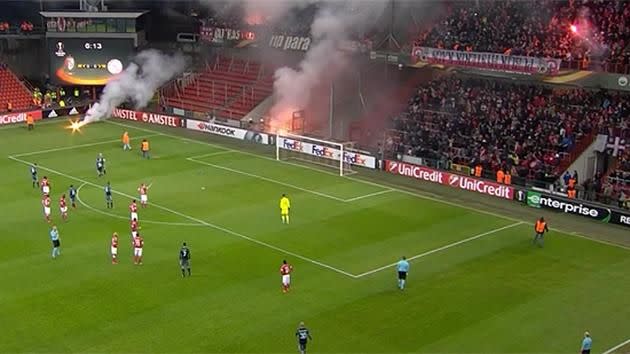 Multiple live flares can be seen in the stands and on the pitch. Pic: YouTube