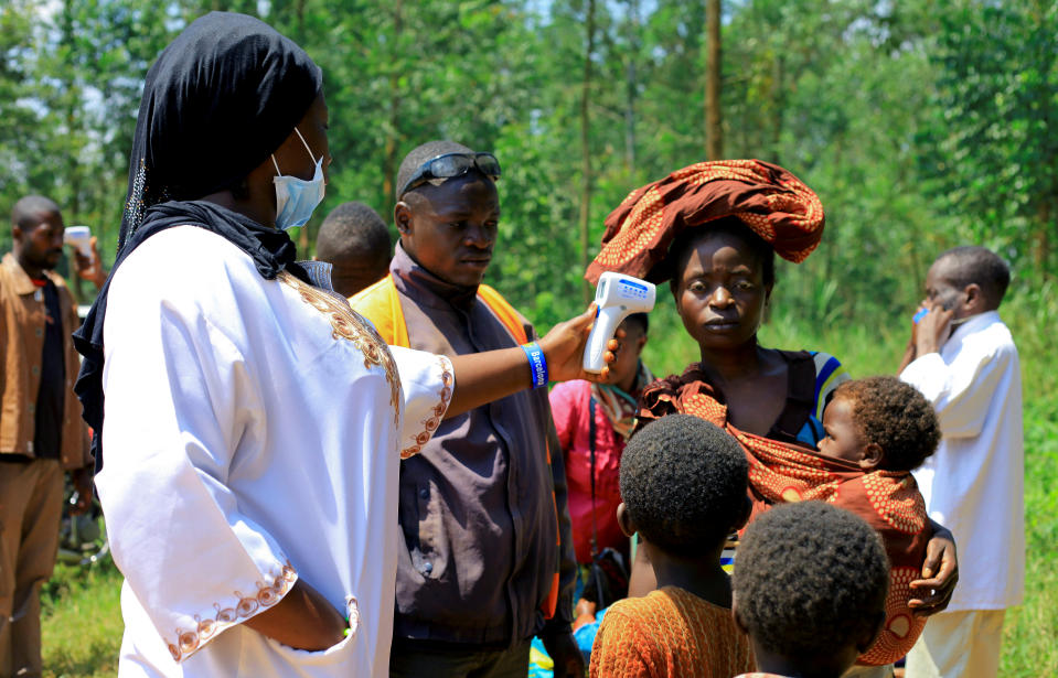 A Congolese health worker checks the temperature of a woman before the launch of vaccination campaign against the deadly Ebola virus near Mangina village, near the town of Beni, in North Kivu province of the Democratic Republic of Congo, August 8, 2018. REUTERS/Samuel Mambo