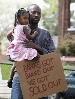 Saidov Wane and his two-year-old daughter Khady protest against home foreclosures in the East Price Hill neighborhood during a Occupy Cincinnati march in Cincinnati, Ohio, March 24, 2012. Occupy activists across America say they have found a cause that represents an issue for the "99 percent" and embodies the movement's anti-Wall Street message: helping struggling homeowners fight foreclosure and eviction. Picture taken March 24, 2012.