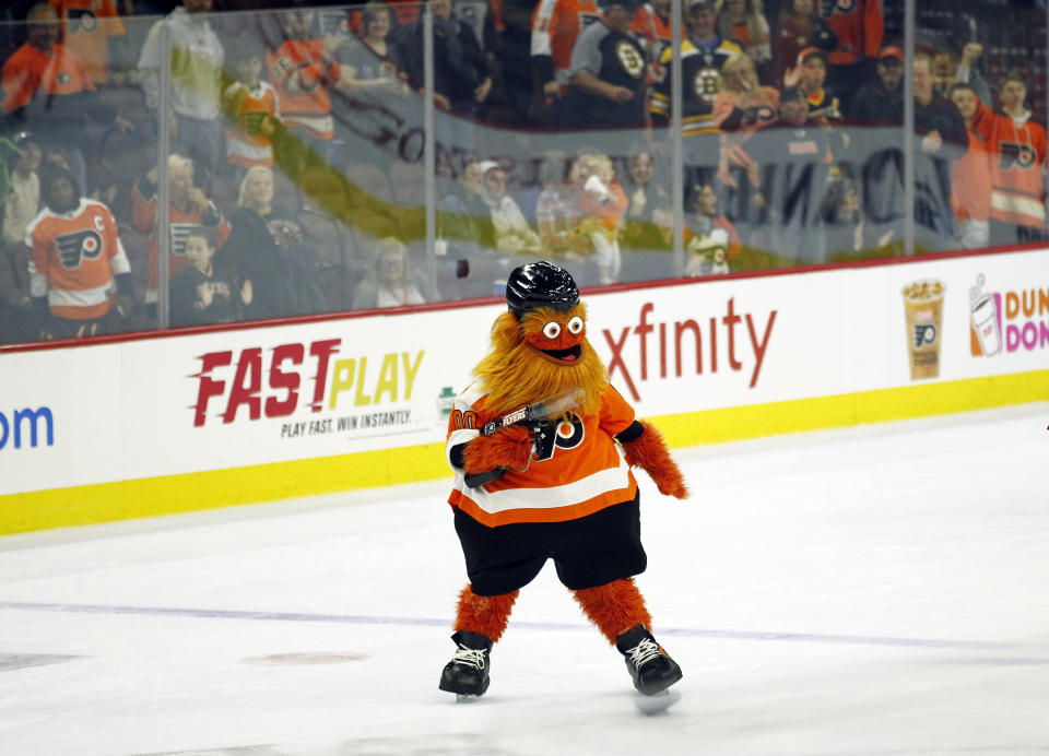 The Philadelphia Flyers mascot, Gritty, shoots T-shirts into the crowd during the second intermission of the Flyers' preseason NHL hockey game against the Boston Bruins, Monday, Sept, 24, 2018, in Philadelphia. (AP Photo/Tom Mihalek)