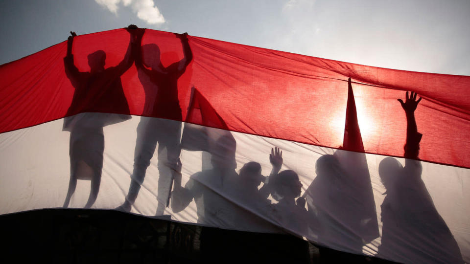 <p>Men are silhouetted against a large representation of the Yemeni flag as they attend a ceremony to mark the anniversary of North Yemen’s Sept. 26, 1962, revolution, in Sanaa, Yemen, Monday, Sept. 26, 2016. (AP Photo/Hani Mohammed)</p>