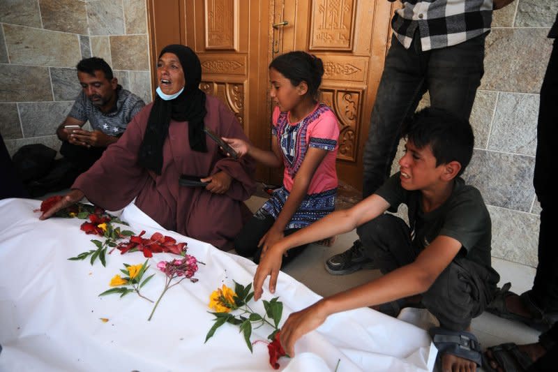 On Wednesday, relatives try to identify the decomposed and dismembered bodies of Palestinians who lost their lives after Israeli attacks in Khan Yunis southern Gaza. The United Nations has called for an “independent, effective and transparent investigation” into the discovery of mass graves at two Gaza hospitals that were besieged and raided by Israeli troops this year. The discovery came after Israel troops left Khan Yunis. Photo by Ismael Mohamad/UPI