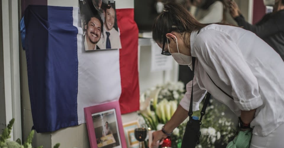 Persona dejando una vela en altar por empresarios asesinados en CDMX