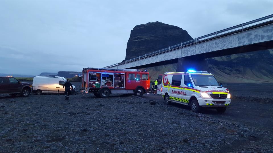 Emergency services at the scene of a crash, in Skeidararsandur, Iceland. An SUV carrying seven members of a British family plunged off a high bridge Thursday in Iceland, killing three people and critically injuring the others, authorities said. (Adolf Erlingsson via AP)