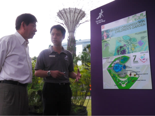 Minister Khaw Boon Wan listens to the plans for the new Children's Garden. (Yahoo! photo/ Deborah Choo)