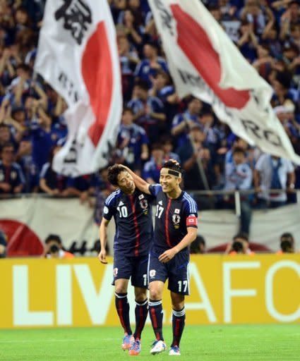 Japan's forward Shinji Kagawa (L) is congratulated by his captain Makoto Hasebe (R) during their 2014 World Cup Asian qualifier football match against Jordan in Saitama