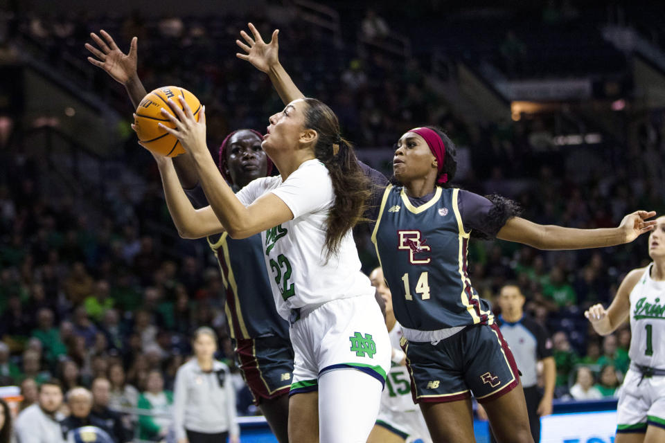 Notre Dame's Kylee Watson (22) drives to the basket as Boston College's Maria Gakdeng, left, and Kayla Lezama (14) defend during the first half of an NCAA college basketball game Sunday, Jan. 1, 2023 in South Bend, Ind. (AP Photo/Michael Caterina)