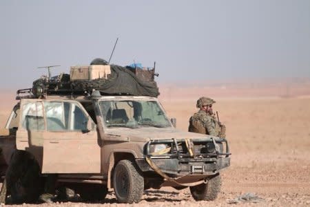 FILE PHOTO: A U.S. fighter stands near a military vehicle, north of Raqqa city, Syria November 6, 2016. REUTERS/Rodi Said